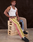 Mixed Stripe Work Pants worn by Isaac sitting on a stack of wooden crates