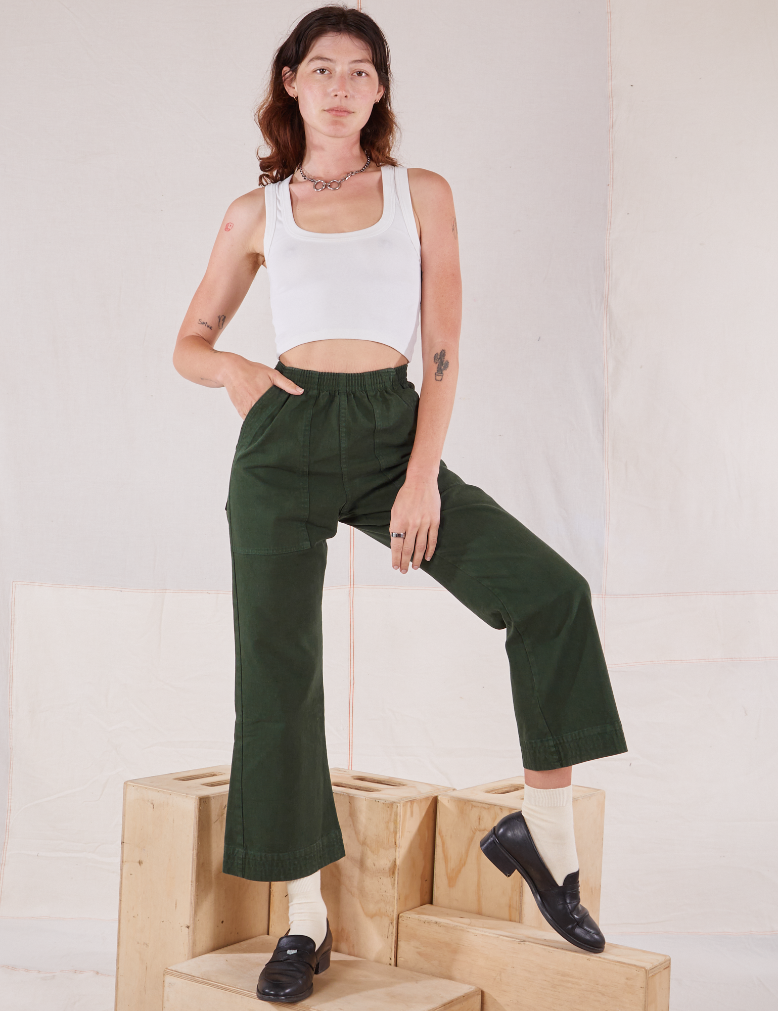 Alex is wearing Action Pants in Swamp Green and Cropped Tank in vintage tee off-white