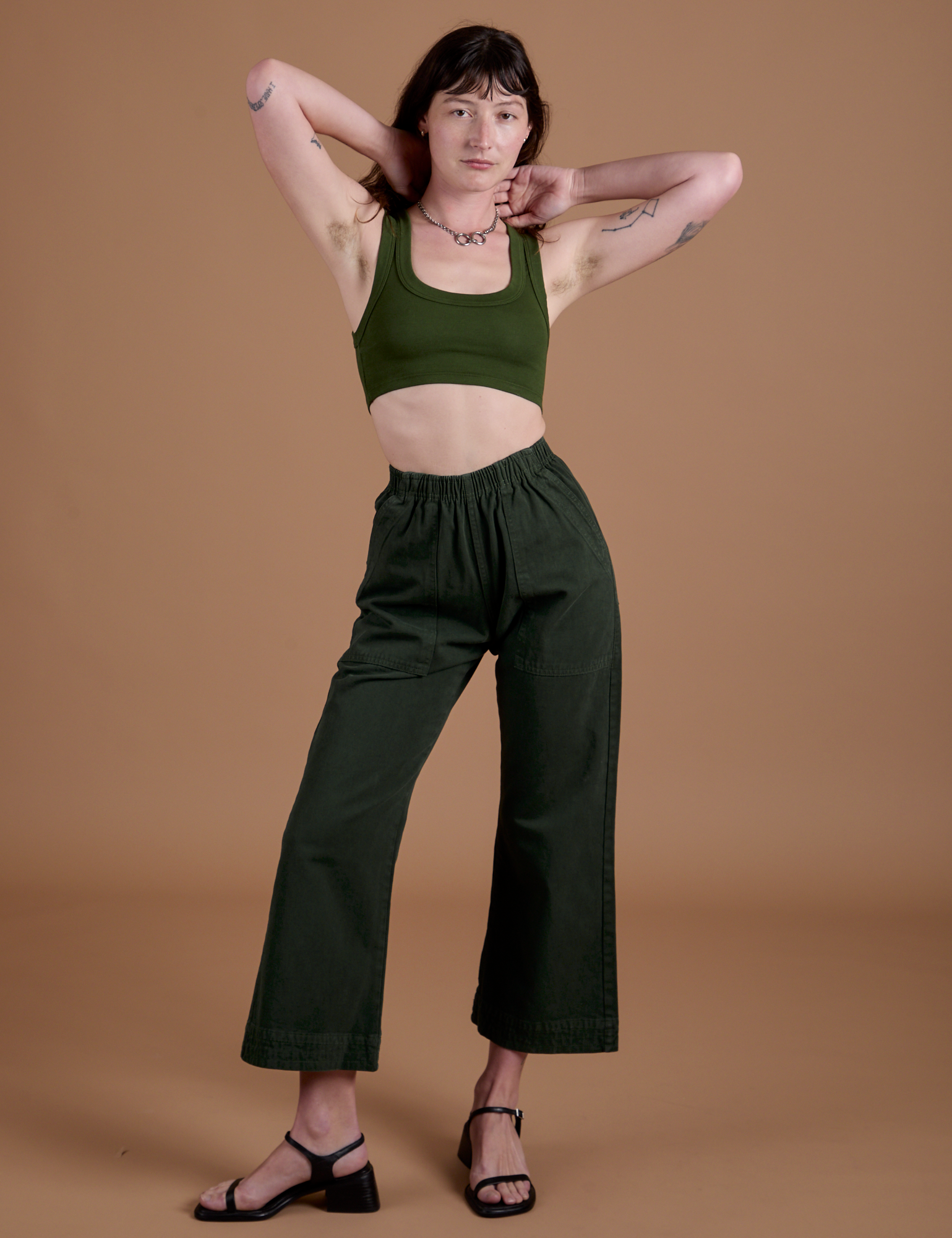 Alex is 5’8” and wearing XXS Action Pants in Swamp Green and evergreen Mini Tank