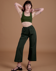 Alex is 5’8” and wearing XXS Action Pants in Swamp Green and evergreen Mini Tank