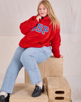 Juliet is wearing Collegiate Hoodie in Mustang Red and light wash Carpenter Jeans