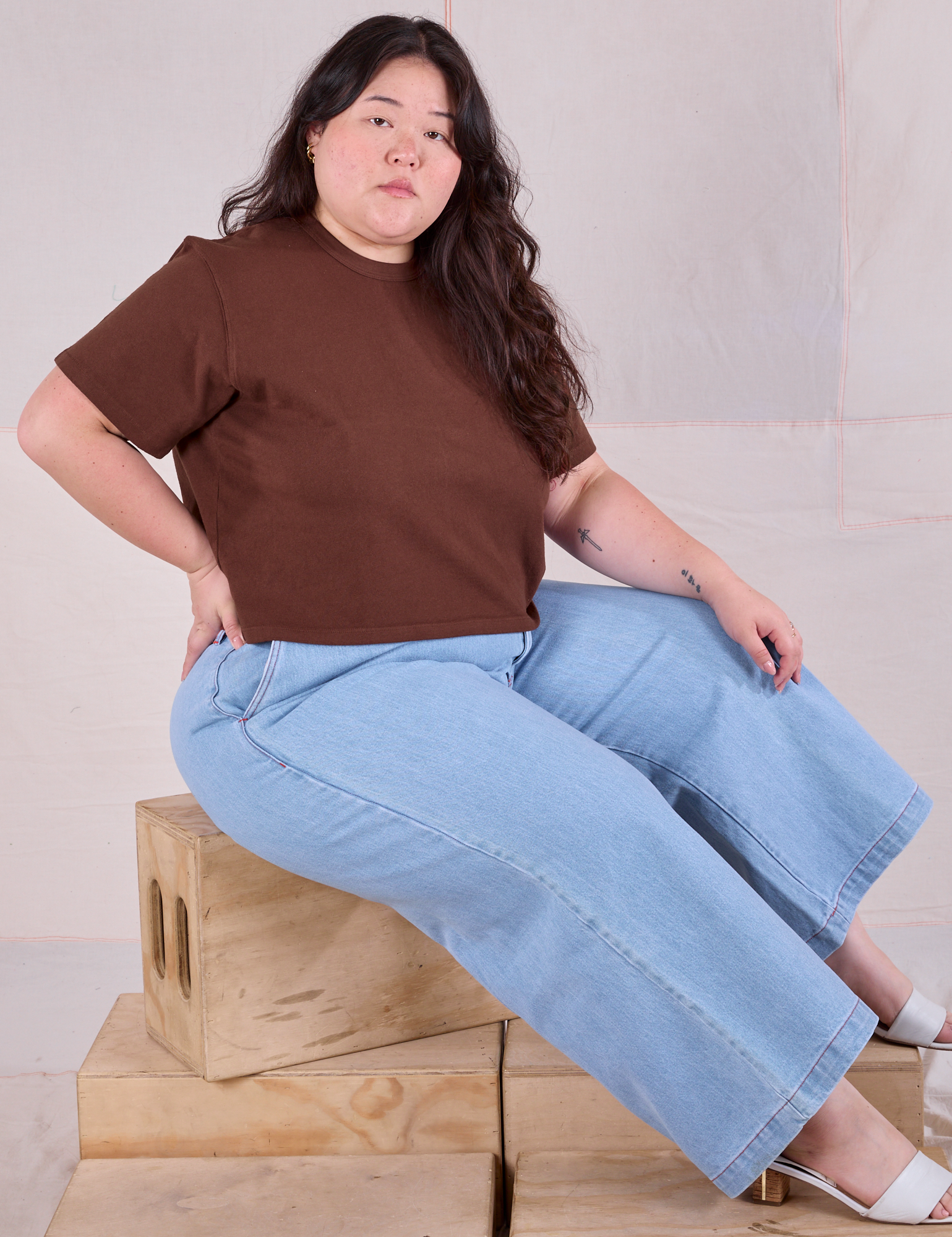 Ashley is wearing Cropped Burly Tee in Fudgesicle Brown and light wash Indigo Wide Leg Trousers