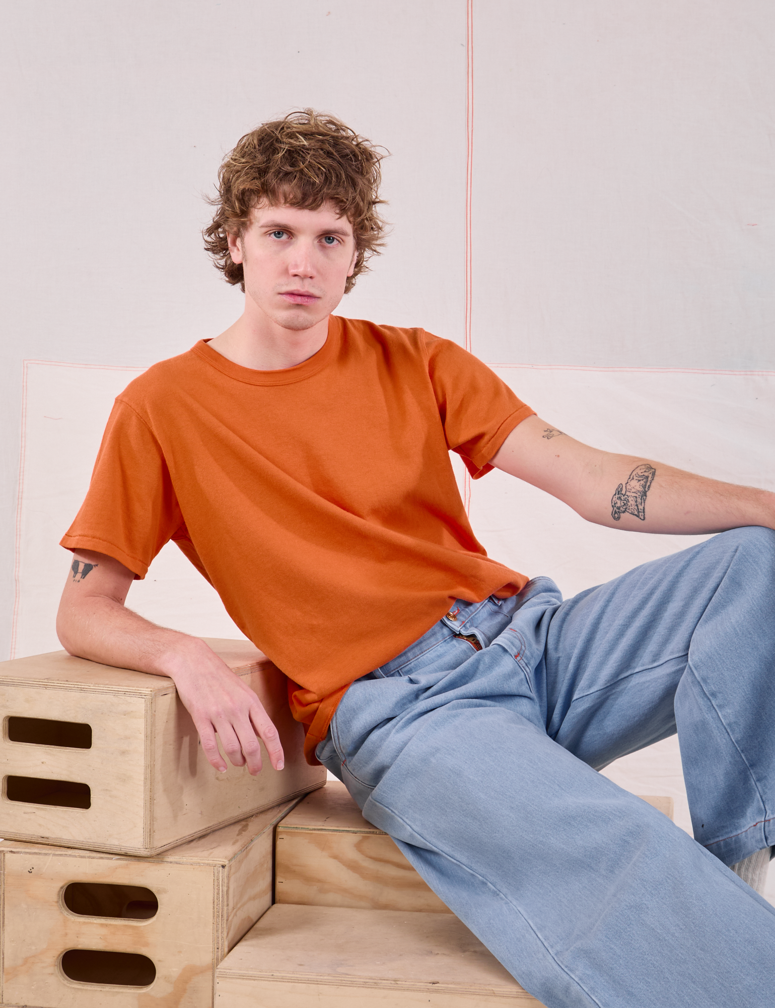 Quinn is wearing Burly Tee in Construction Orange and light wash Wide Leg Trouser Jeans