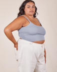 Angled view of Cropped Cami in Periwinkle and vintage off-white Western Pants worn by Alicia