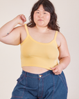 Ashley is 5’7” and wearing L Cropped Cami in Butter Yellow paired with dark wash Carpenter Jeans
