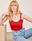 Margaret is wearing Cropped Cami in Mustang Red and light wash Carpenter Jeans