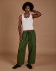 Jerrod is 6’3” and wearing M Drop Pocket Cargo Pants in Evergreen paired with a Tank Top in vintage tee white