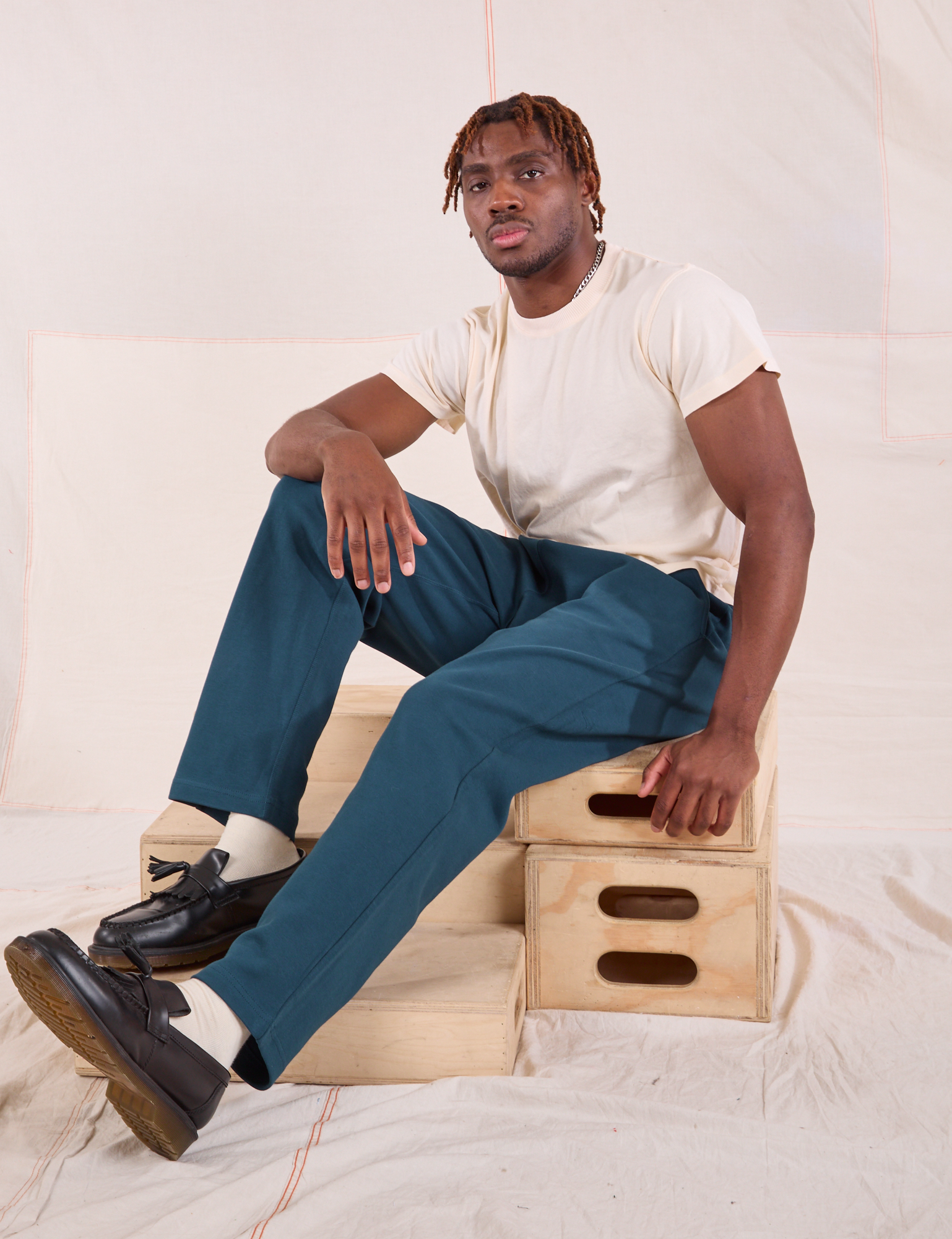 Issac is wearing Easy Pants in Lagoon and Organic Vintage Tee in vintage tee off-white