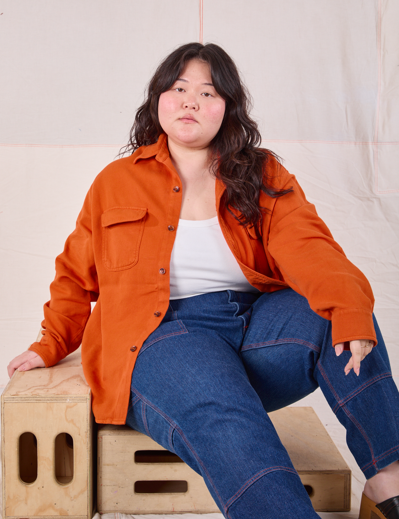 Ashley is wearing Flannel Overshirt in Burnt Orange and dark wash Carpenter Jeans