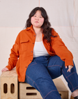 Ashley is wearing Flannel Overshirt in Burnt Orange and dark wash Carpenter Jeans