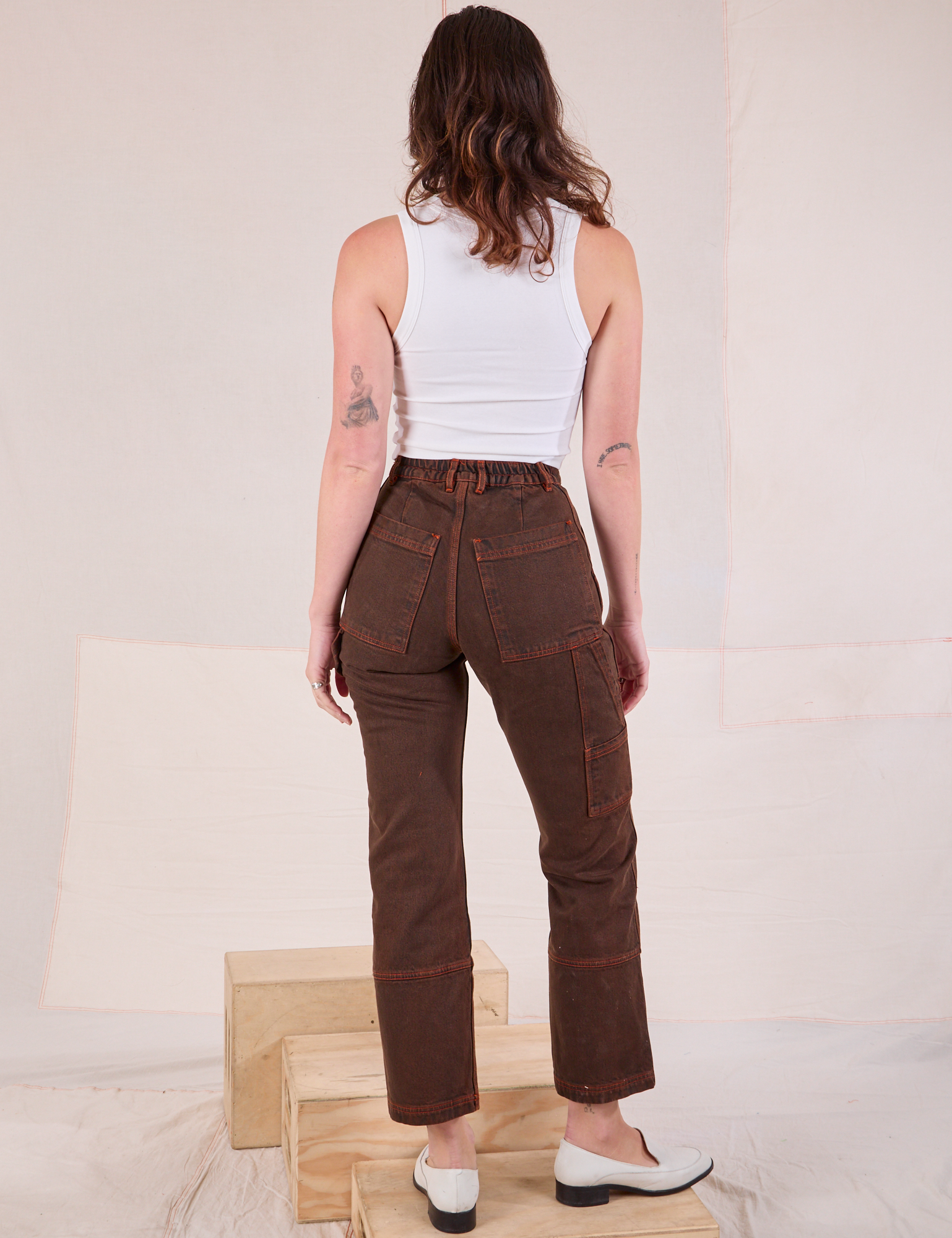 Back view of Overdyed Carpenter Jeans in Fudge and Cropped Tank in vintage tee off-white on Alex