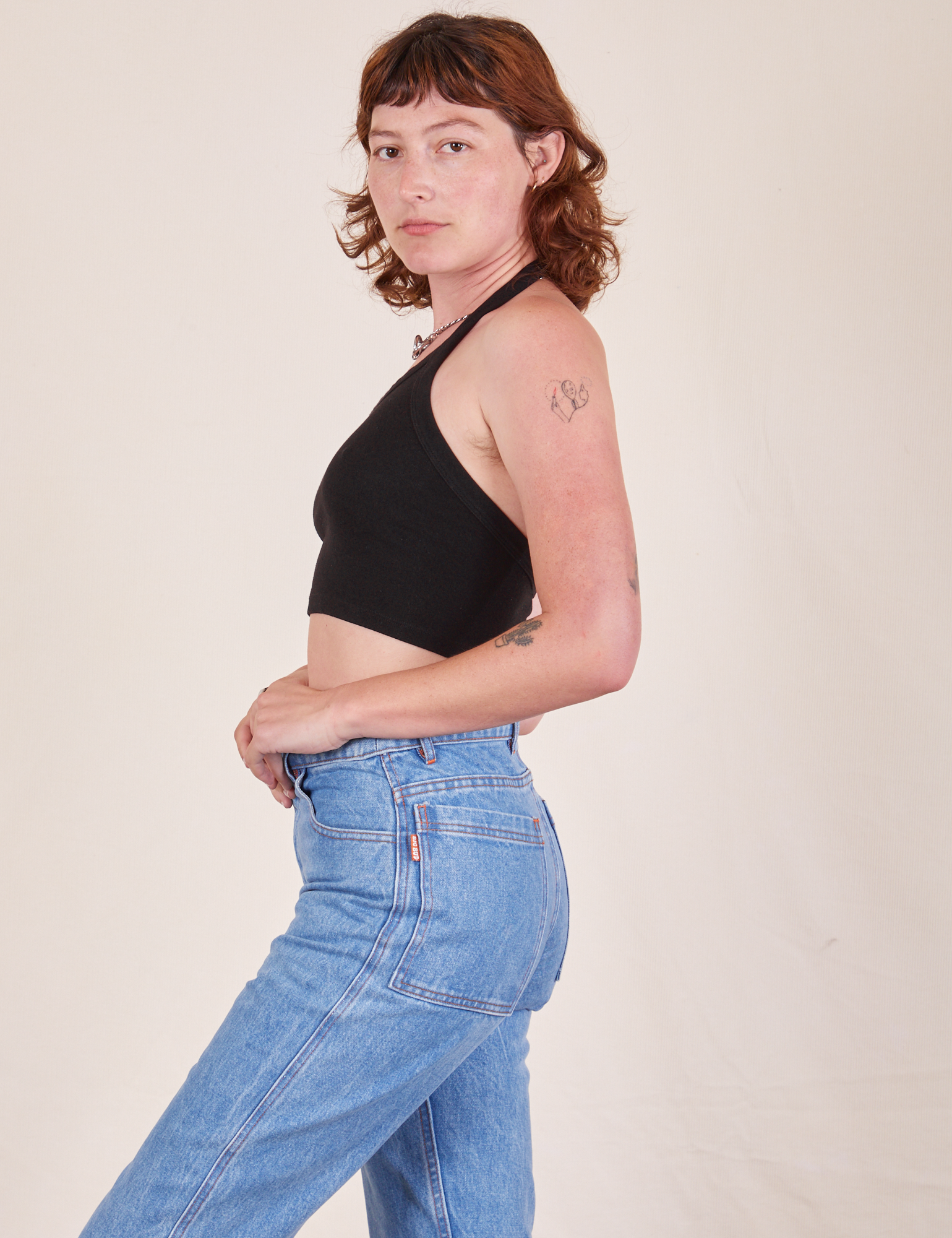 Side view of Halter Top in Basic Black and light wash Frontier Jeans worn by Alex