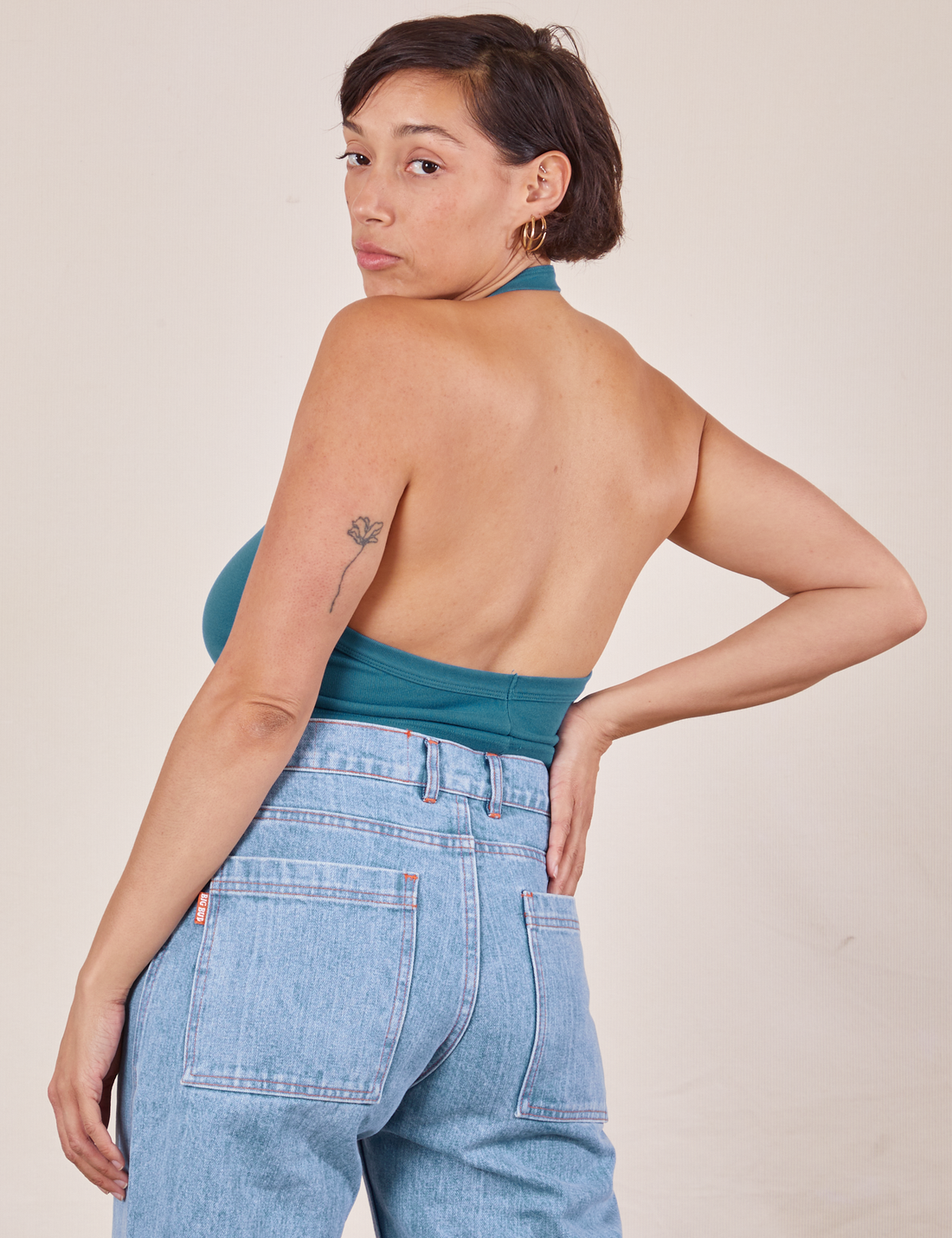 Angled back view of Halter Top in Marine Blue and light wash Sailor Jeans worn by Tiara