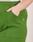 Cropped Rolled Cuff Sweatpants in Lawn Green front pocket close up. Marielena has her hand in the pocket.