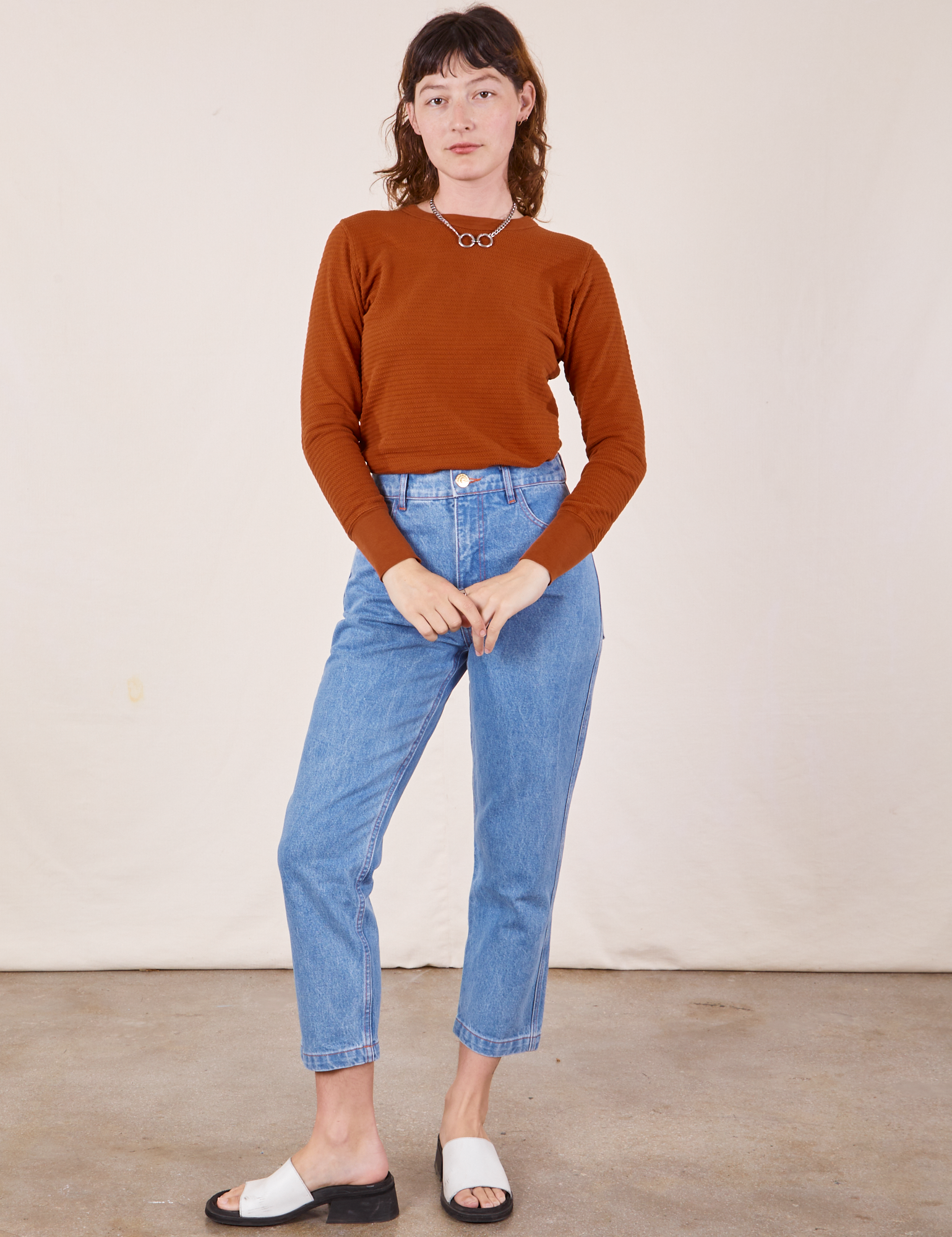 Alex is wearing Honeycomb Thermal in Burnt Terracotta tucked into light wash Frontier Jeans