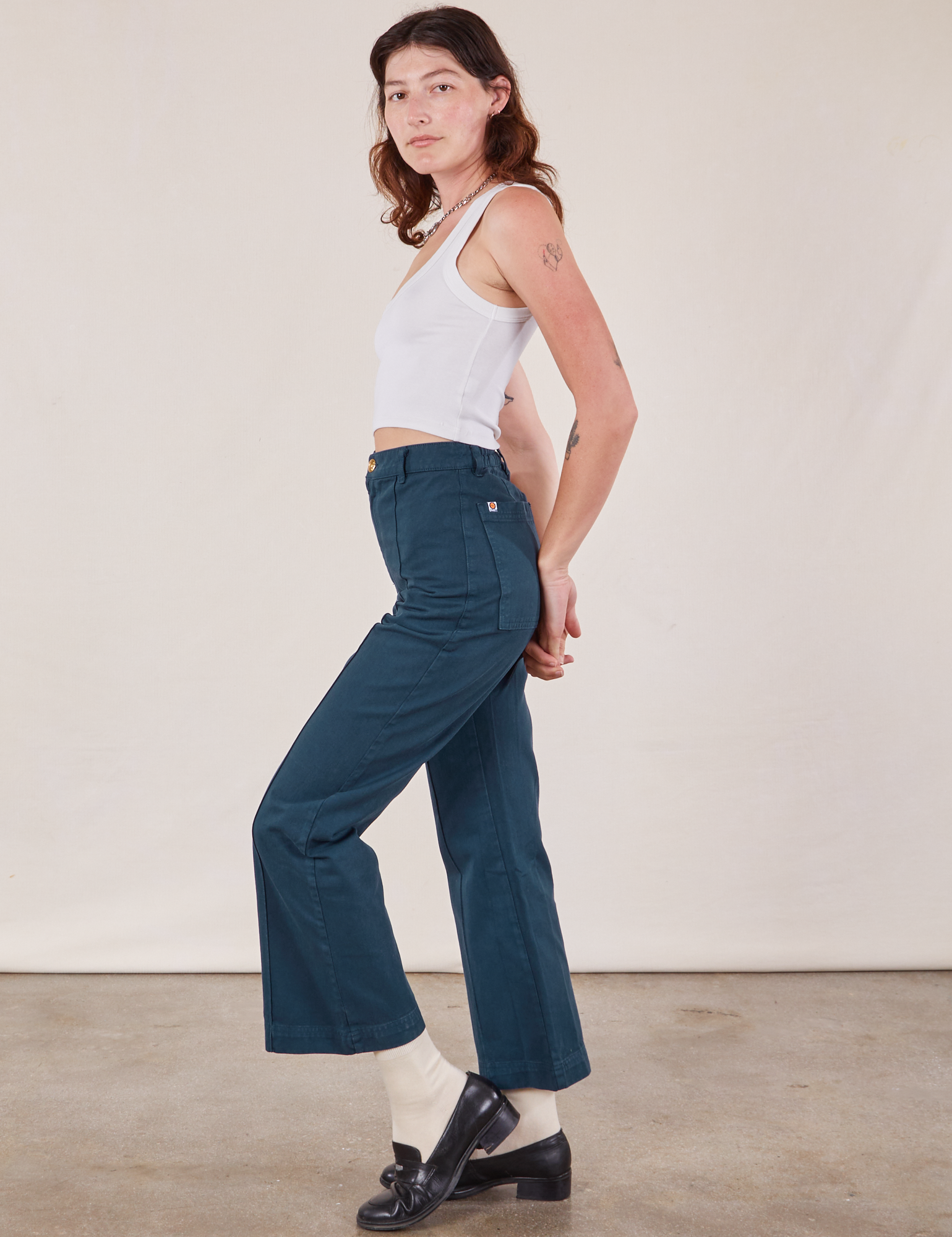 Side view of Western Pants in Lagoon and vintage tee off-white Cropped Tank on Alex
