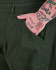 Close up of Sam's hand in the pocket of a Long Jumpsuit in Swamp Green