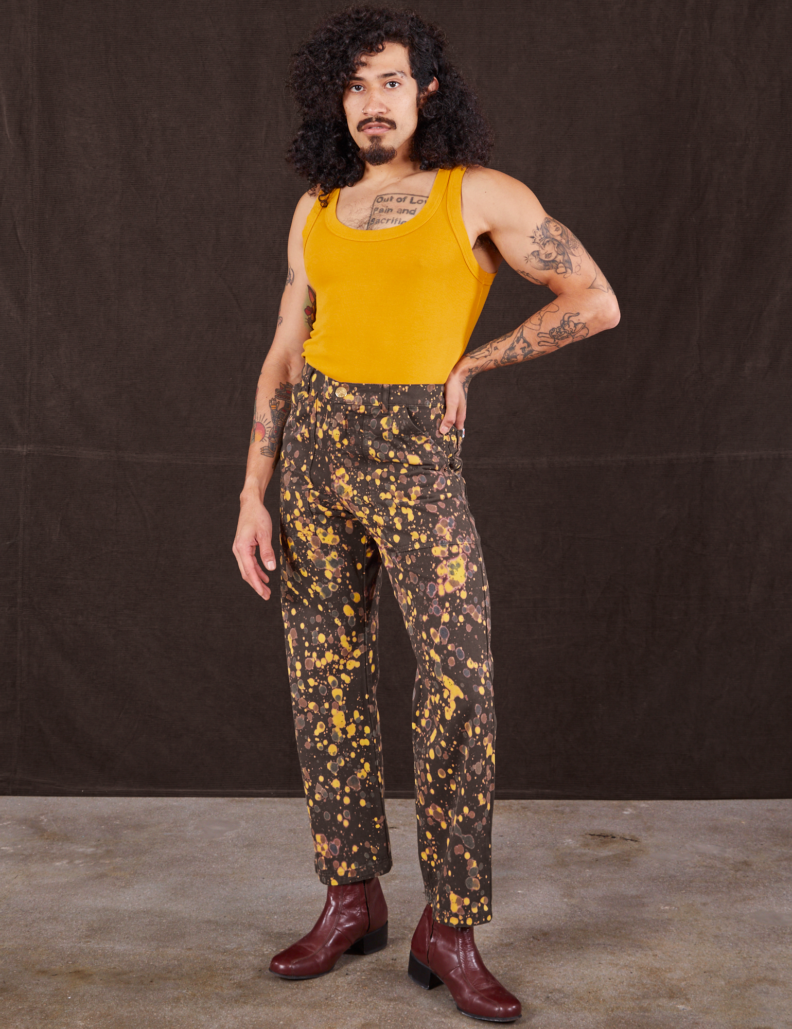 Jesse is 5&#39;8&quot; and wearing XS Marble Splatter Work Pants in Espresso Brown paired with mustard yellow Tank Top