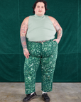 Sam is 5'10" and wearing 3XL Marble Splatter Work Pants in Hunter Green paired with sage green Sleeveless Turtleneck