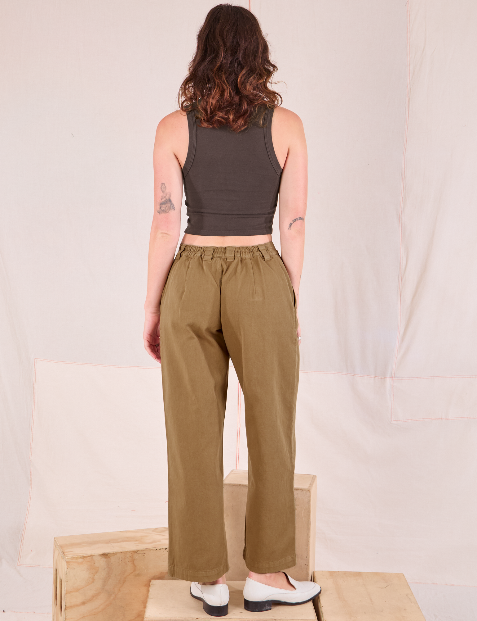 Back view of Mid-Rise Pleated Trousers in Desert Brown and espresso brown Cropped Tank on Alex