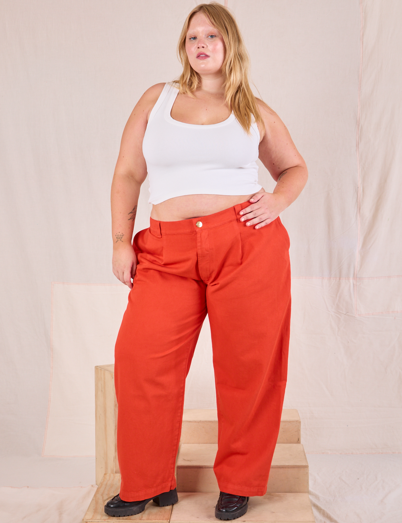 Juliet is wearing Mid-Rise Pleated Trousers in Chili Red and Cropped Tank in vintage tee off-white