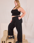 Side view of Mid-Rise Pleated Trousers in Basic Black and black Cropped Tank