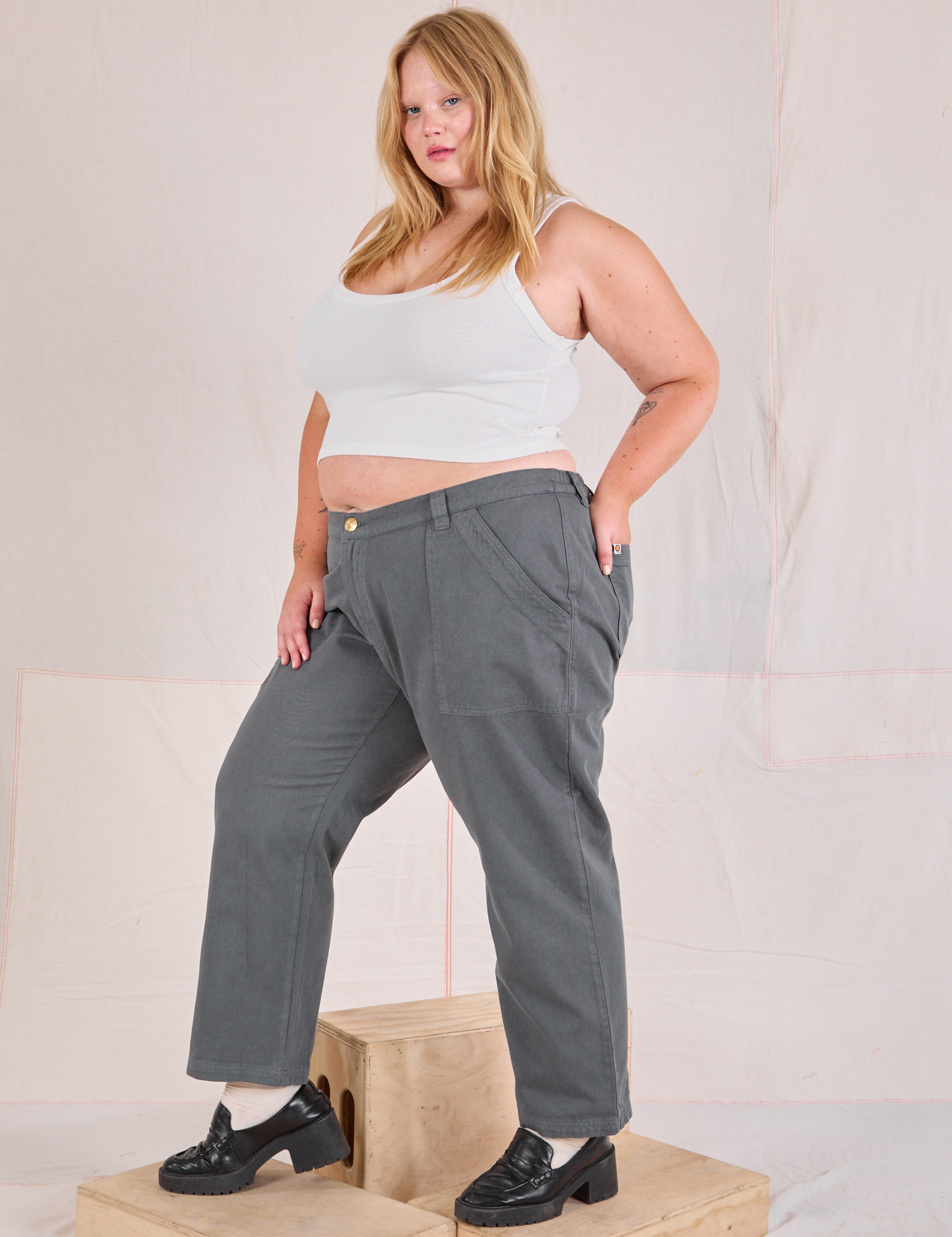 Angled front view of Mid-Rise Work Pants in Slate Grey and Cropped Tank in vintage tee off-white on Juliet