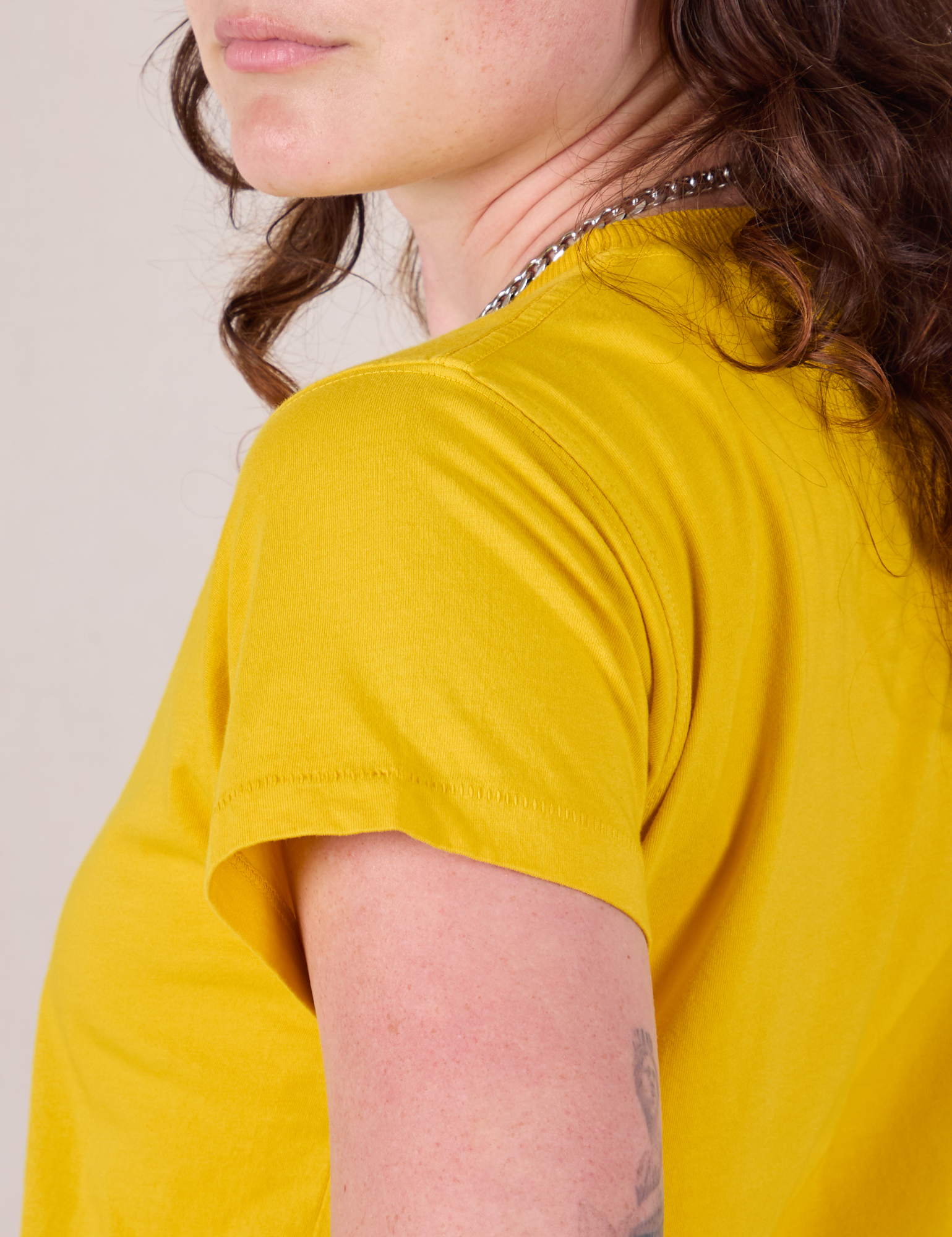 Organic Vintage Tee in Golden Yellow shoulder close up on Alex