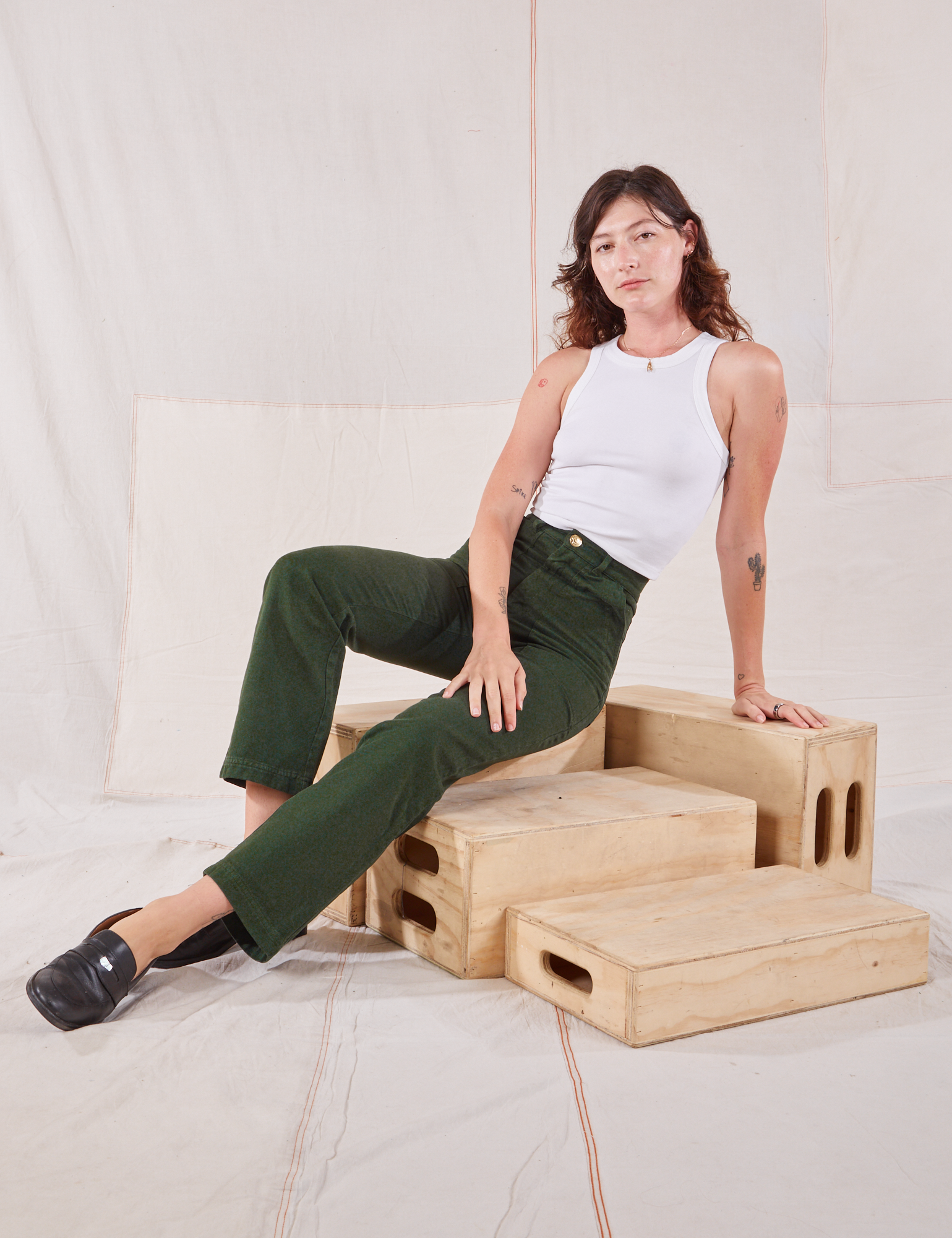 Alex is wearing Organic Work Pants in Swamp Green and Racerback Tank in vintage tee off-white