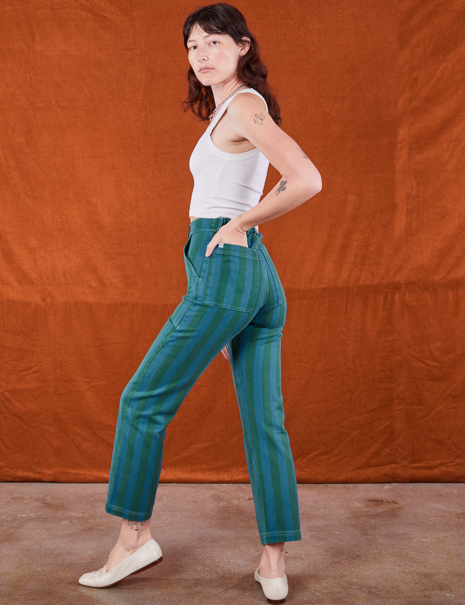 Side view of Overdye Stripe Work Pants in Blue/Green and vintage off-white Cropped Tank Top on Alex