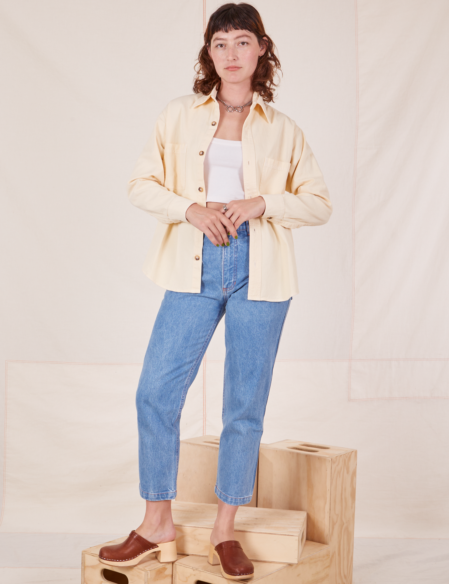 Alex is wearing Oversize Overshirt in Vintage Off-White, Cropped Tank Top in vintage off-white and light wash Frontier Jeans
