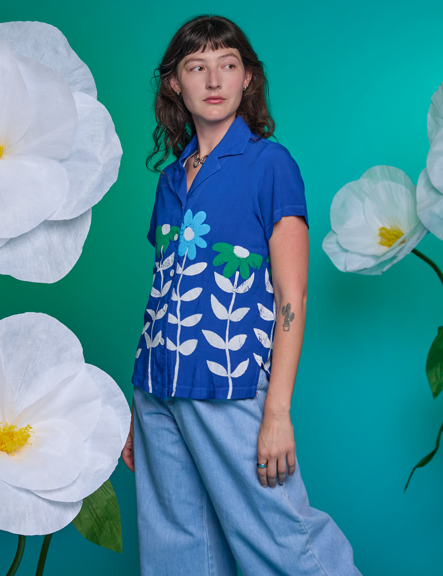 Alex is wearing Paintstamped Pantry Button-Up in Daisy and light wash Indigo Wide Leg Trousers