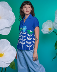 Alex is wearing Paintstamped Pantry Button-Up in Daisy and light wash Indigo Wide Leg Trousers