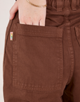 Petite Bell Bottoms in Fudgesicle Brown back pocket close up. Hana has her hand in the pocket.