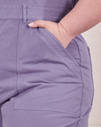 Front pocket close up of Petite Short Sleeve Jumpsuit in Faded Grape. Ashley has her hand in the pocket.