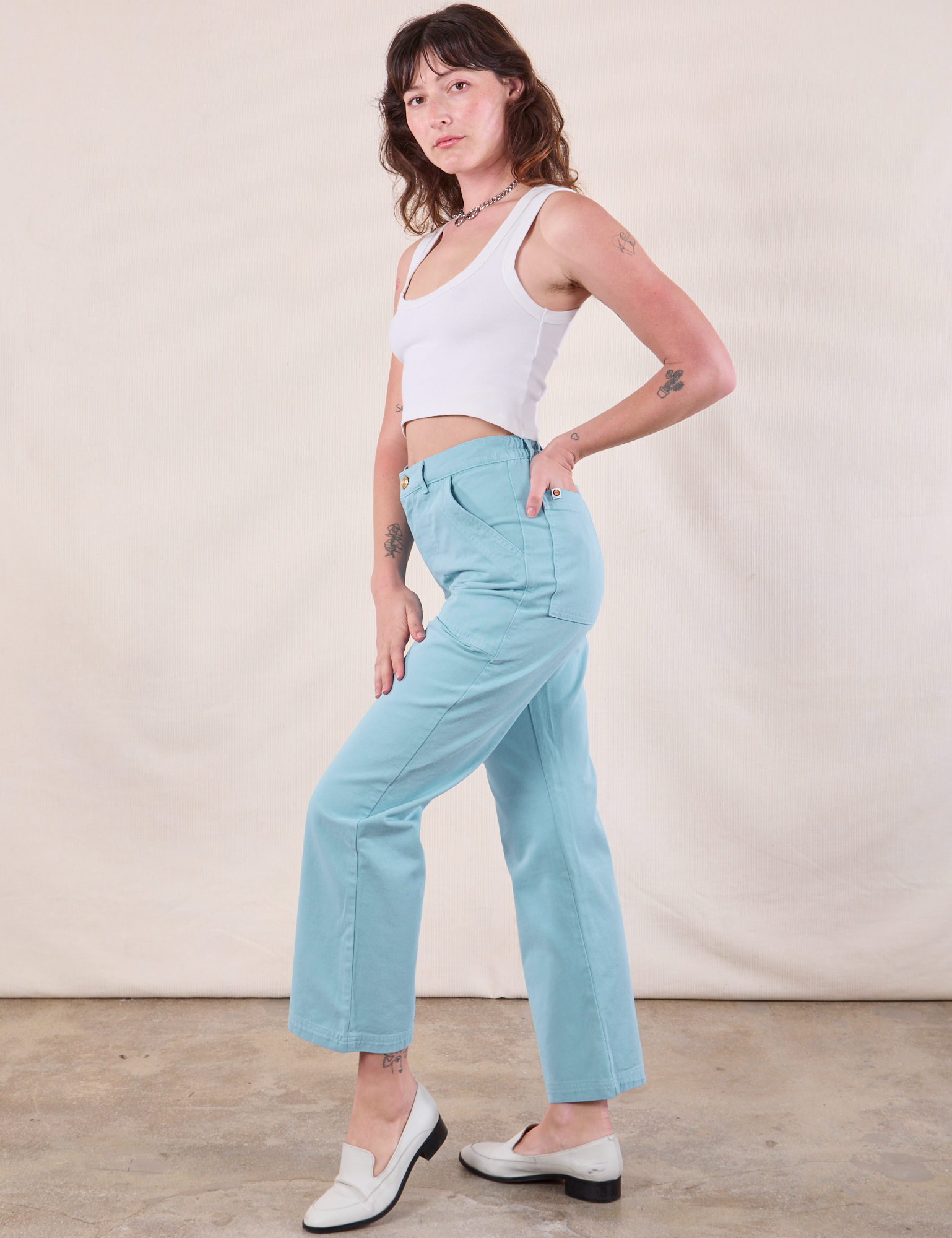 Side view of Work Pants in Baby Blue and Cropped Tank in Vintage Tee Off-White on Alex