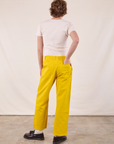 Back view of Work Pants in Golden Yellow and Burly Tee in Vintage Tee Off-White on Quinn