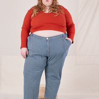 Catie is 5'11" and wearing 5XL Railroad Stripe Denim Work Pants paired with a paprika Long Sleeve V-Neck Tee