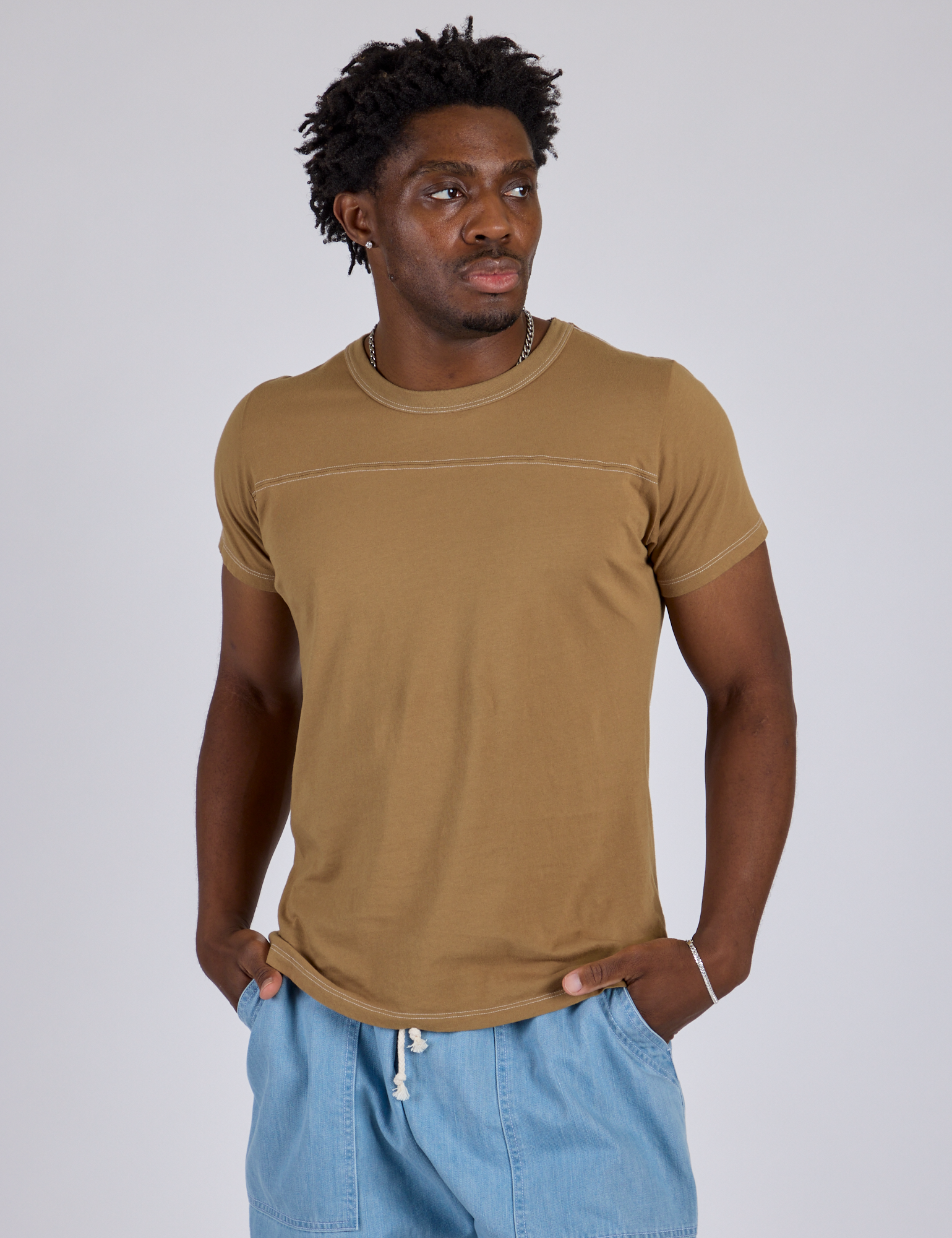 Isaac is 5’10” and wearing M Jr. Varsity Tee in Desert Brown