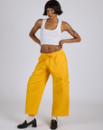 Kira is wearing Drop Pocket Cargo Pants in Sunshine Yellow and vintage tee white Cropped Tank