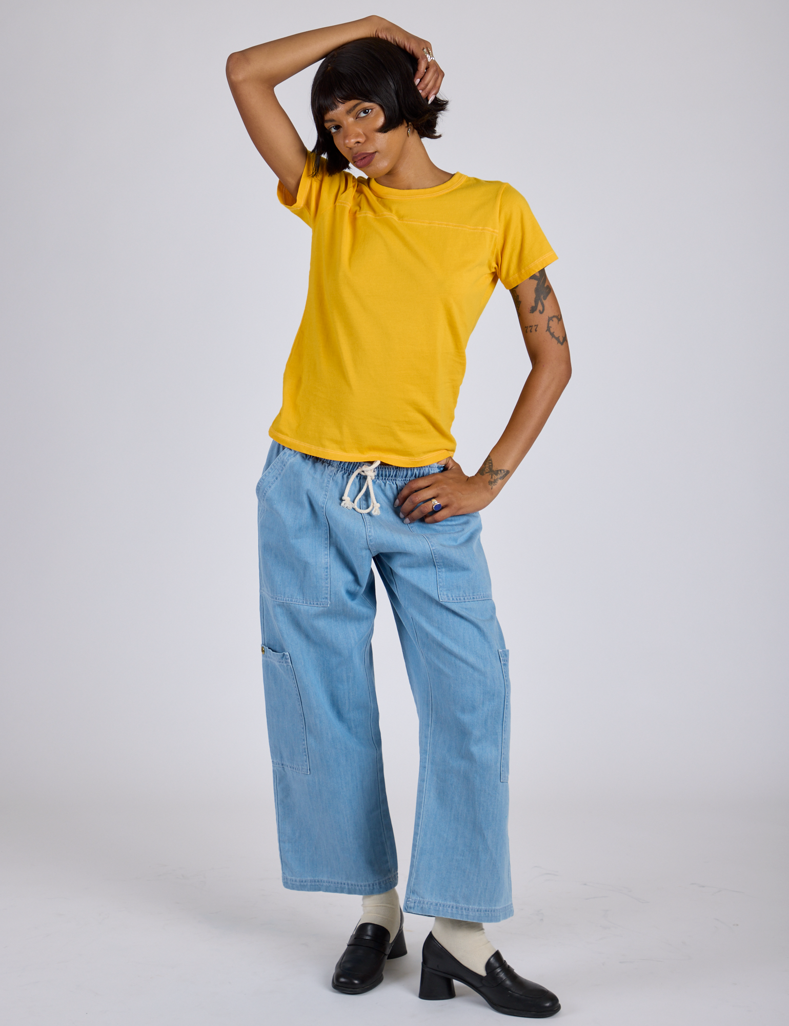 Kira is wearing Jr. Varsity Tee in Sunshine Yellow and light wash Denim Drop Pocket Pants