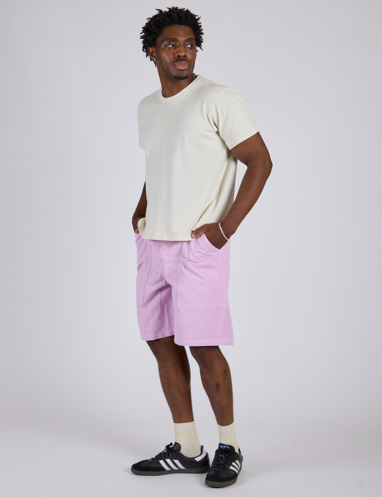 Angled front view of Longline Work Shorts in Lilac Purple and vintage tee white Burly Tee on Isaac