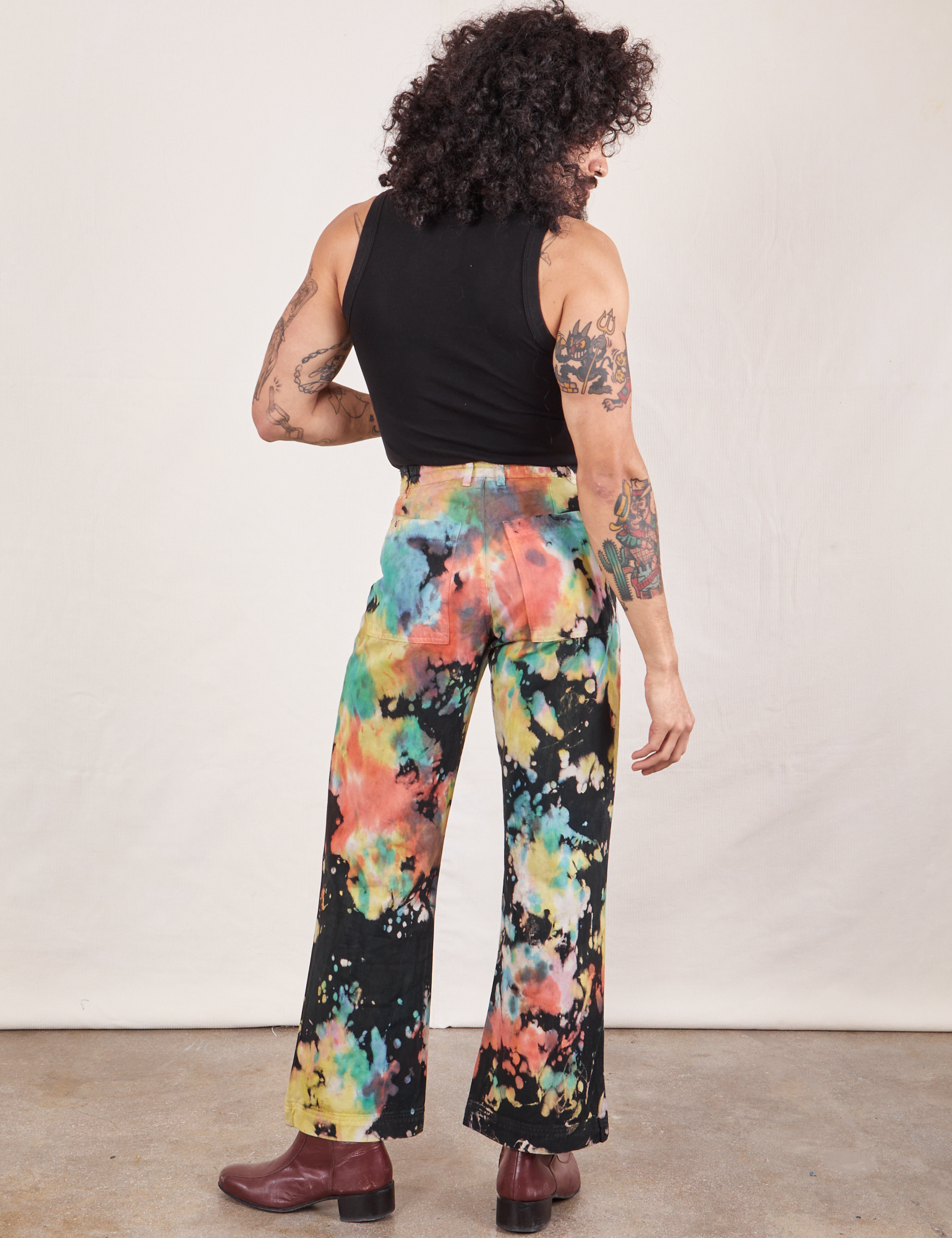 Back view of Western Pants in Rainbow Magic Waters and black Tank Top on Jesse
