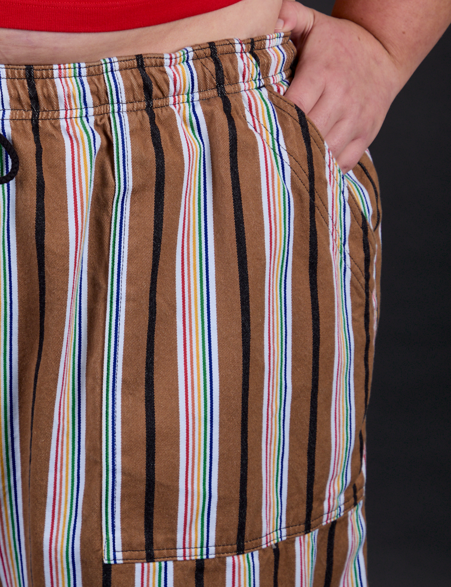 Close up of Juliet's hand in the front pocket of Striped Drop Pocket Pants in Retro Rainbow