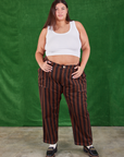 Katie is 6'2" and wearing 2XL Black Stripe Work Pants in Fudgesicle Brown paired with a Cropped Tank in vintage tee off-white