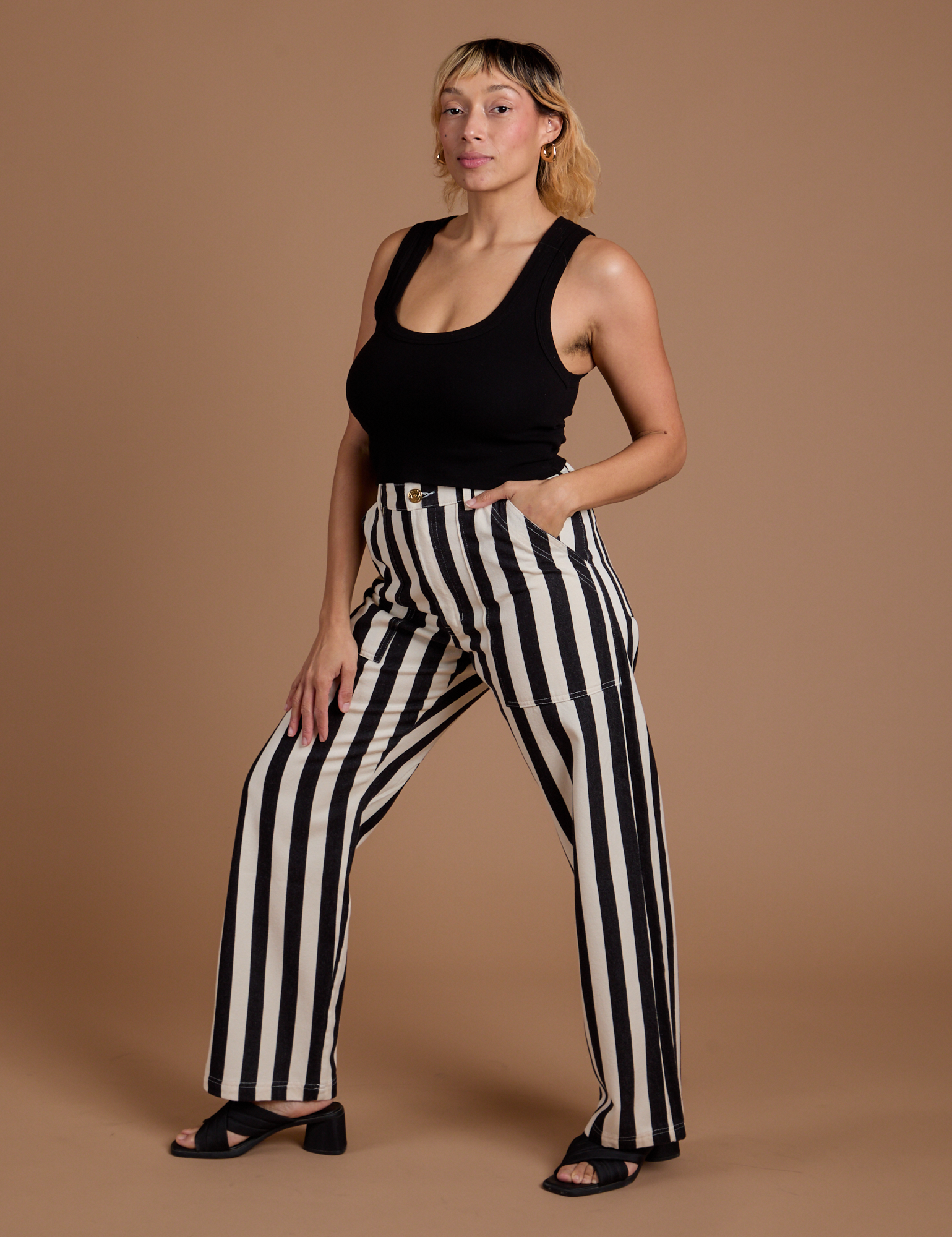 Angled front view of Black Stripe Work Pants in White and black Cropped Tank on Tiara