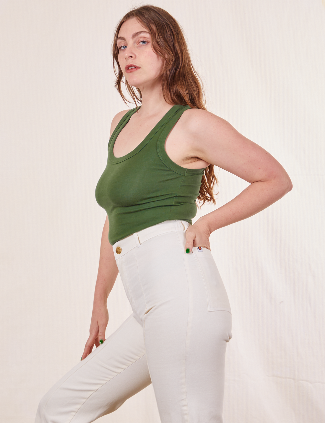 Tank Top in Dark Emerald Green side view on Allison wearing vintage off-white Western Pants. Allison has her hand in the back pocket of pants.