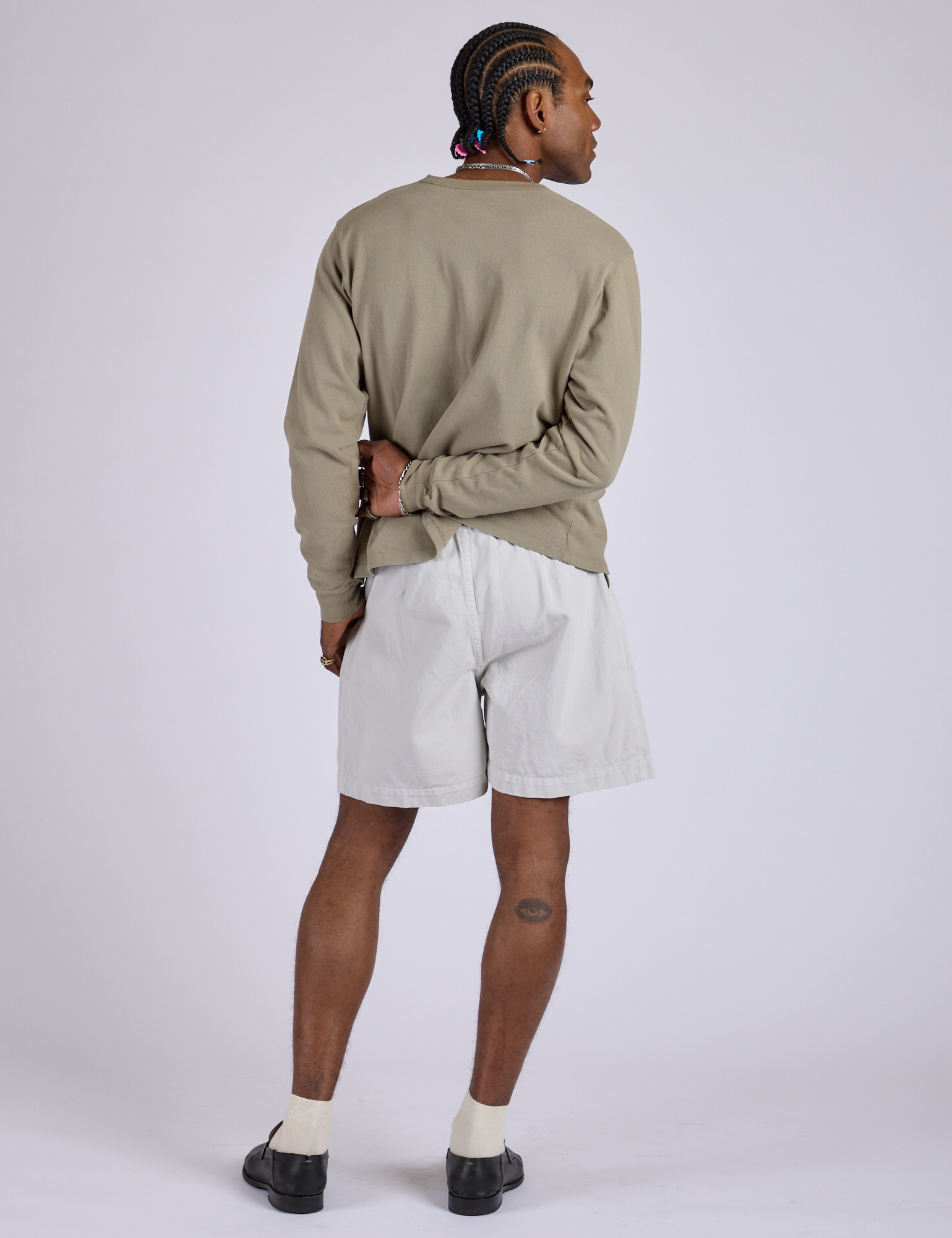 Back view of Pleated Trouser Shorts in Dishwater White and khaki grey Long Sleeve Burly Tee on Jerrod