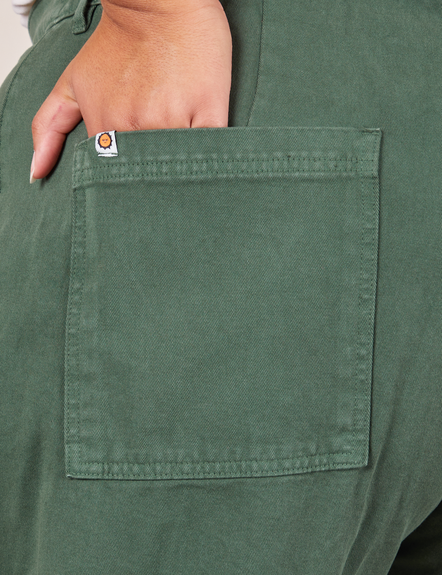 Back pocket close up of Western Pants in Dark Green Emerald. Alicia has her hand in the pocket.