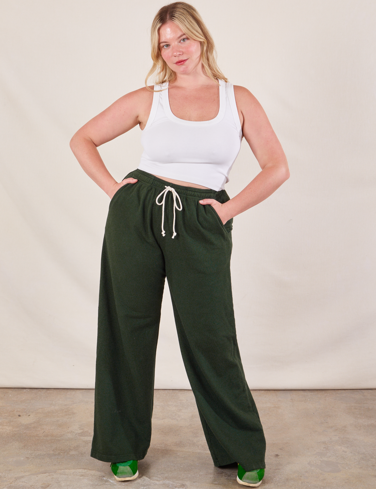 Lish is 5&#39;8&quot; and wearing M Wide Leg Sweat Pants in Swamp Green paired with Cropped Tank in vintage tee off-white